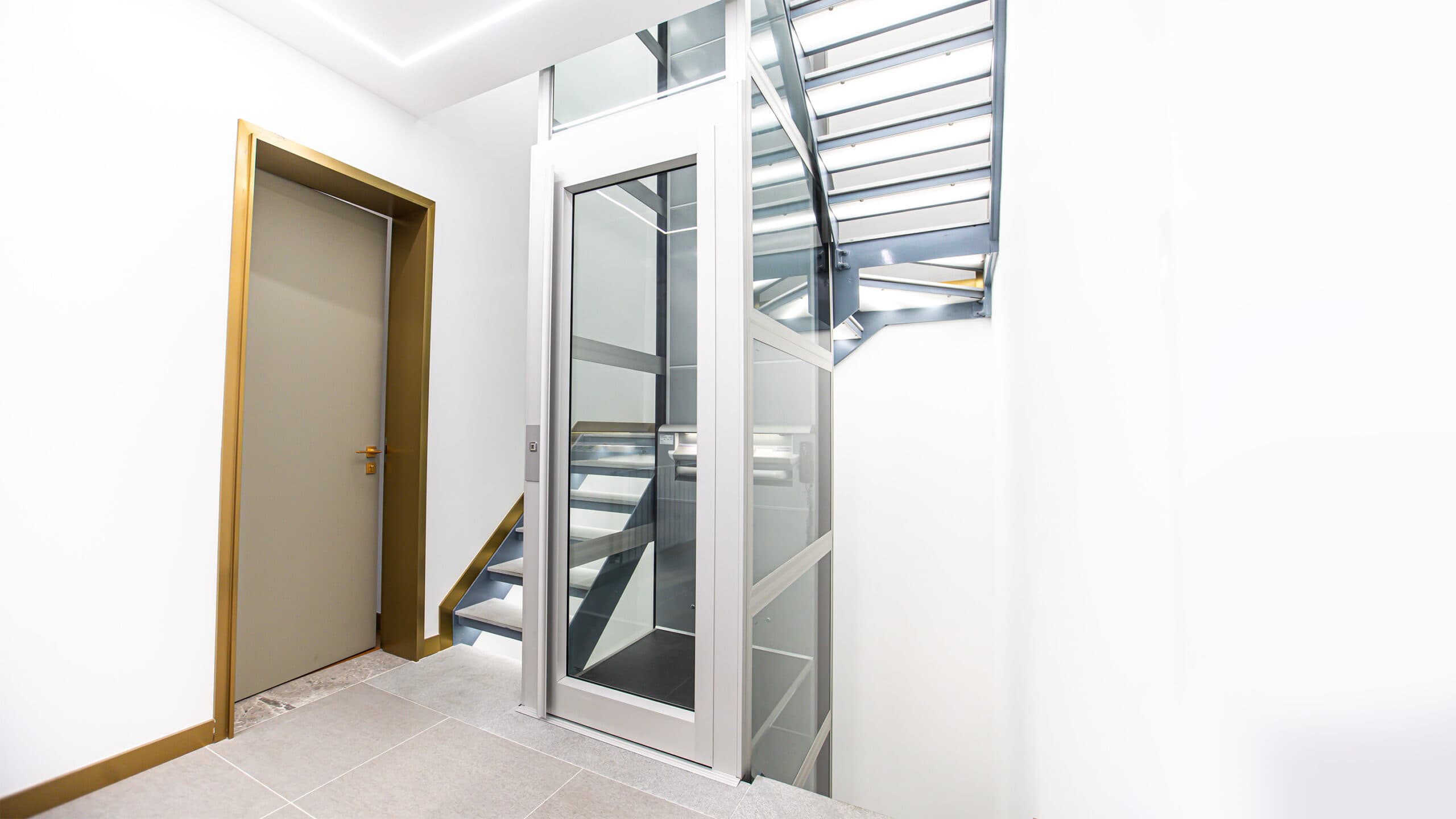 Kalea A4 Mini residential lift installed in a townhouse staircase, highlighting its minimalist aesthetics, efficient use of space and user-friendly accessibility, making it a premium residential lift solution for modern family homes.
